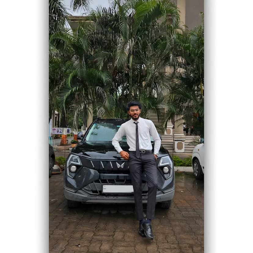 Umer Saiyad, a Full Stack developer from India, posing outdoor next to a clean, polished car under bright daylight.